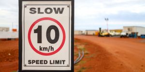 30 km h speed limit sign next to gravel road at mine camp