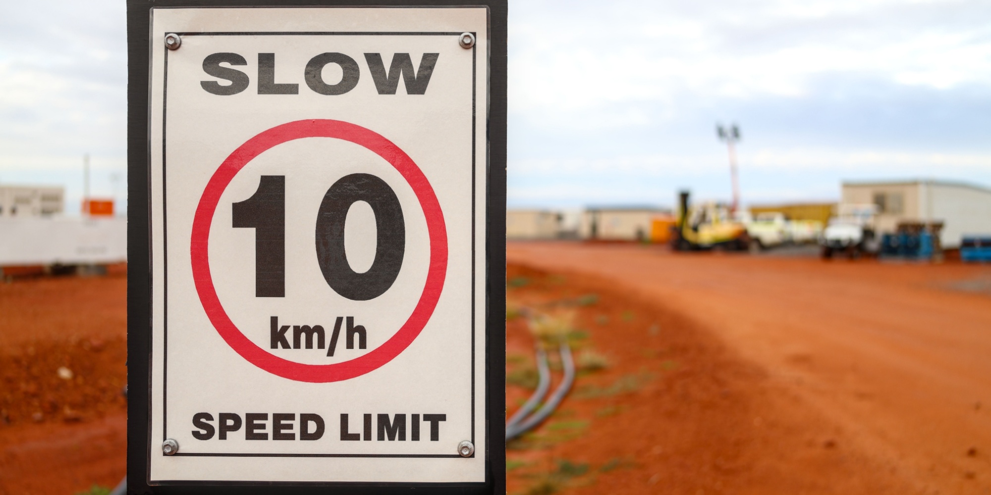 30 km h speed limit sign next to gravel road at mine camp